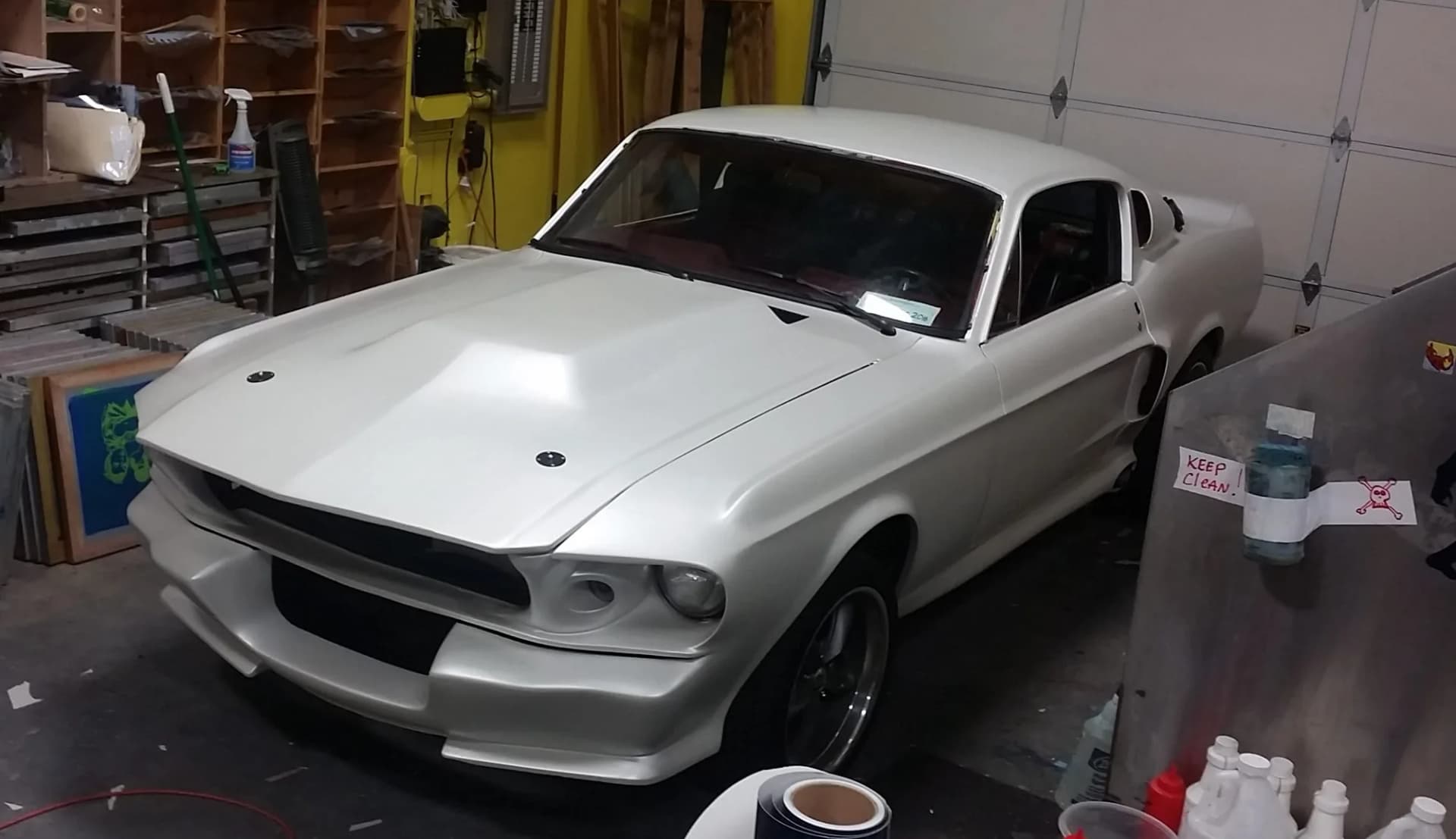 Ford Mustang Fastback in satin white inside the Oly Wraps shop during a build