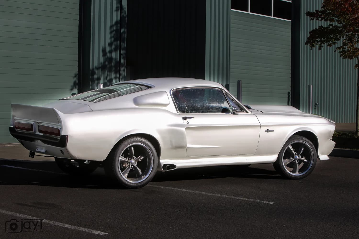 Ford Mustang Fastback wrapped in satin white vinyl, parked outside the Oly Wraps shop in Olympia, Washington